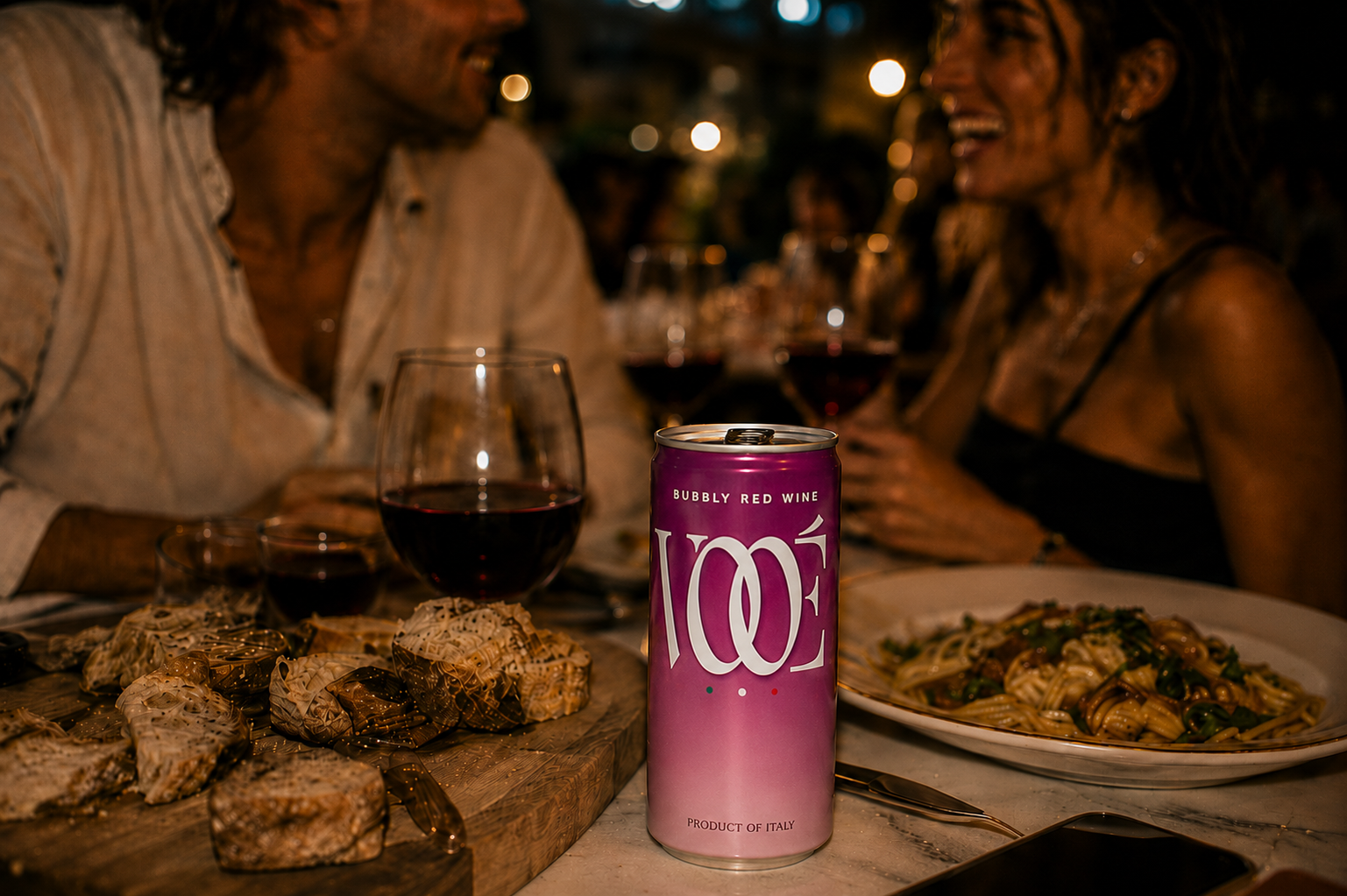 Dinner table with VOOÉ Bubbly Red, friends in the background